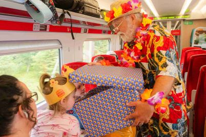Summer-Santa-surprises-young-customers-with-Christmas-presents-on-LNER-train_cropped-scaled-1.jpg